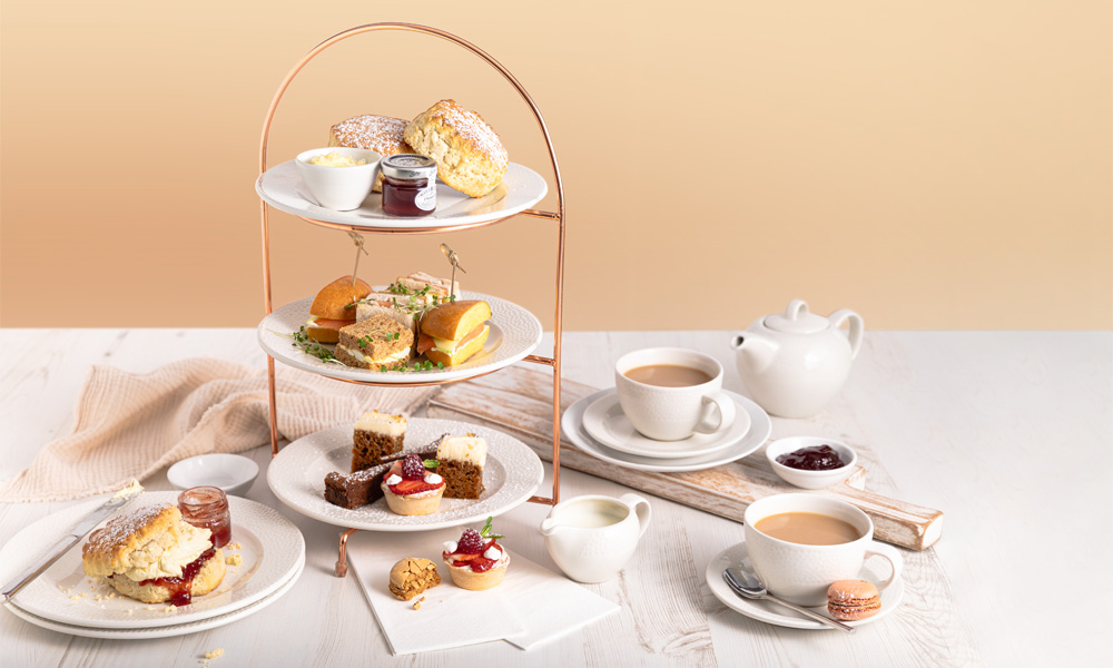 Stacked Afternoon Tea served with a pot of tea.