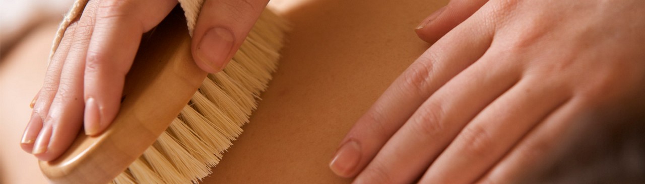 Therapist brushing ladies back for exfoliation