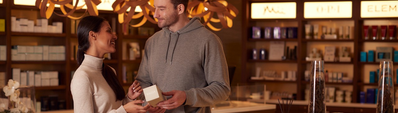 Man and woman standing in the Aqua Sana Boutique looking at the products available.