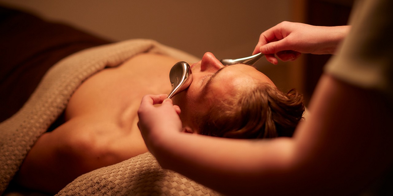 Woman having a facial with little brushes.