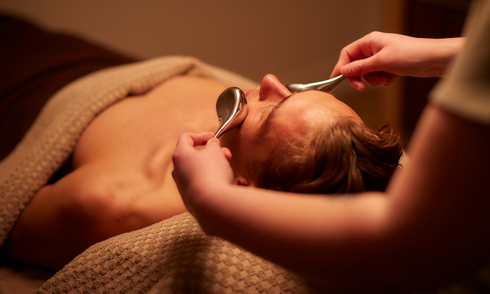 Man having a facial with smooth metal devices.