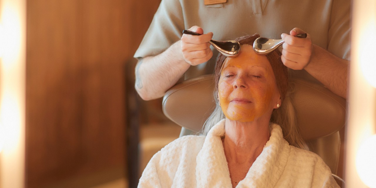Woman having a facial with smooth metal devices.