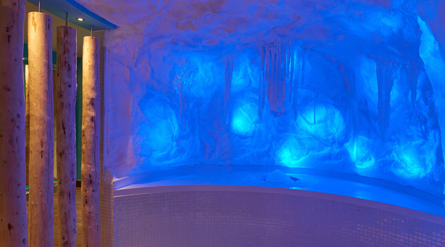 Inside of an ice cave with icicles hanging from the ceiling.