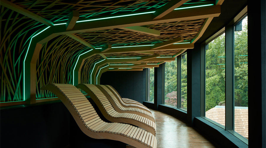 Wooden lounging chairs with a decorative ceiling design above.