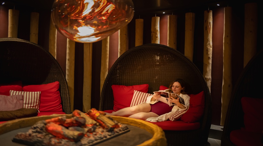A ladt relaxing on a coccoon in the fireside relax room.