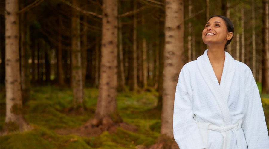 Woman smiling as she looks out at the forest.