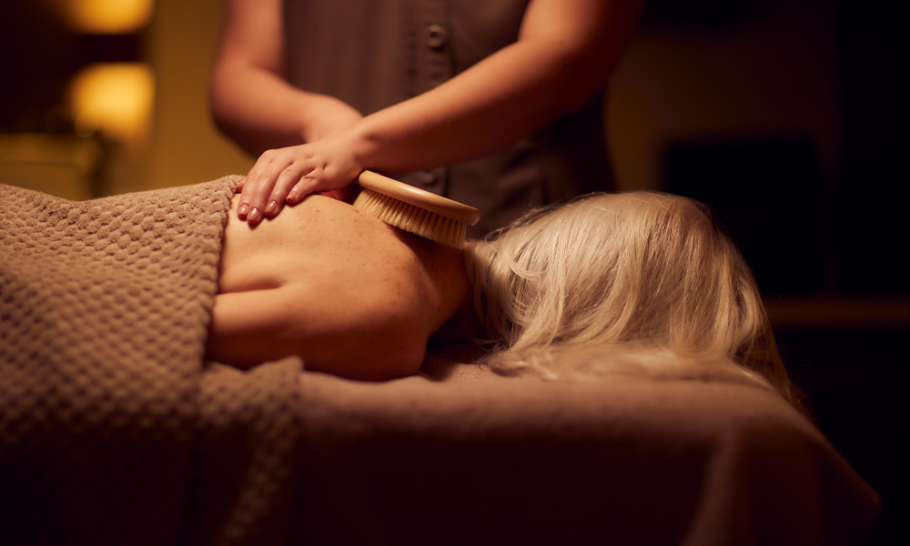 Woman having a brush stroked against her back.