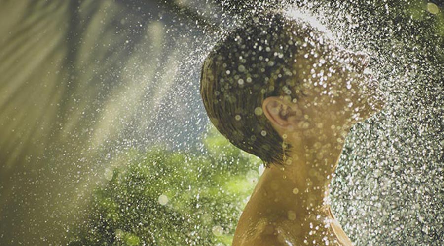 person with face under shower 