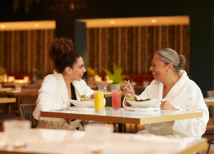 Two women sitting eating and drinking in the Vitalé Café Bar.