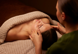 Woman having her head rubbed by a trained spa therapist.