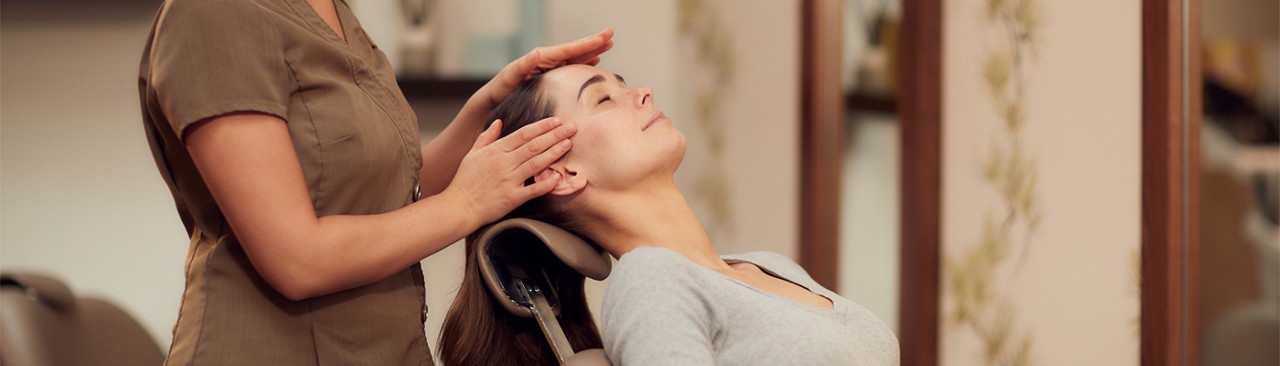 Woman laid back having her head touched.