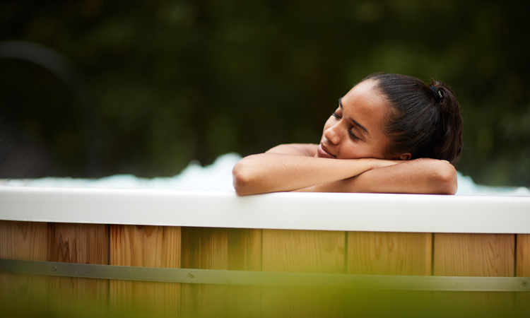 Woman leaning on the edge of a bubbling hot tub.