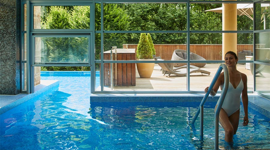Woman walking out on a pool which is both inside and outside.