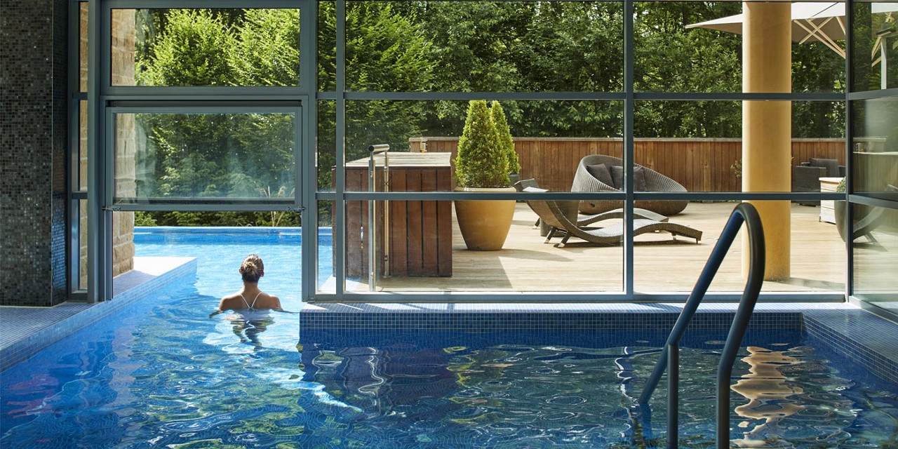 women in pool with forest view