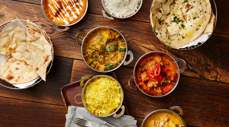 A selection of curries served with rice and naan bread.