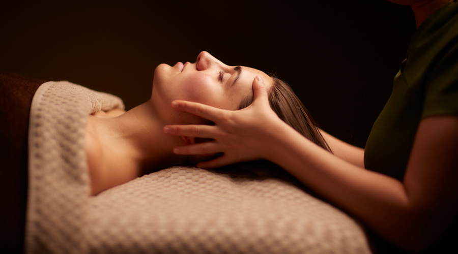 Woman having her head rubbed by a trained spa therapist.