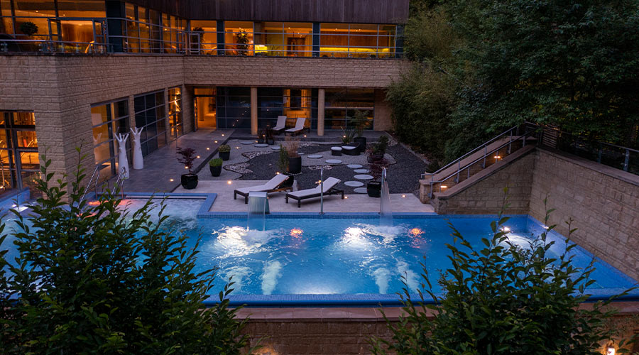 Outdoor pool in the evening, surrounded by the forest.