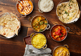 A selection of Indian dishes including, rice, naan bread and a variety of curries.
