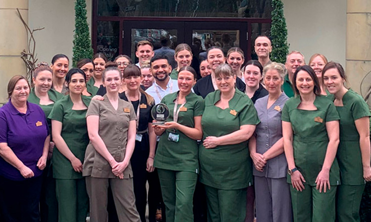 Group of Aqua Sana staff members holding a trophy