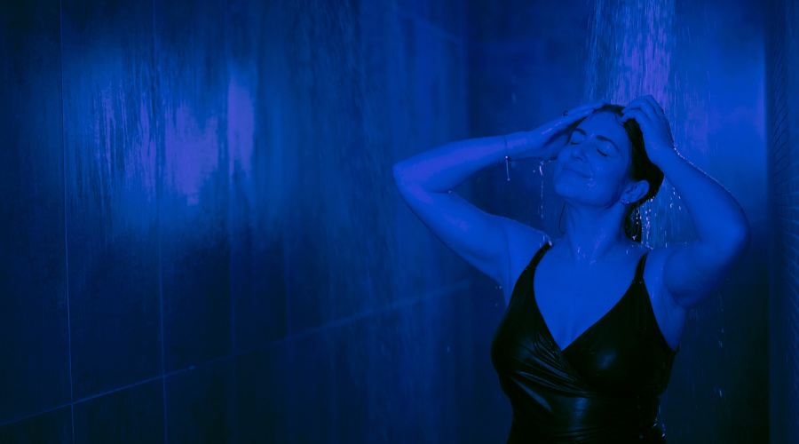 Woman soaking in a rainfall shower