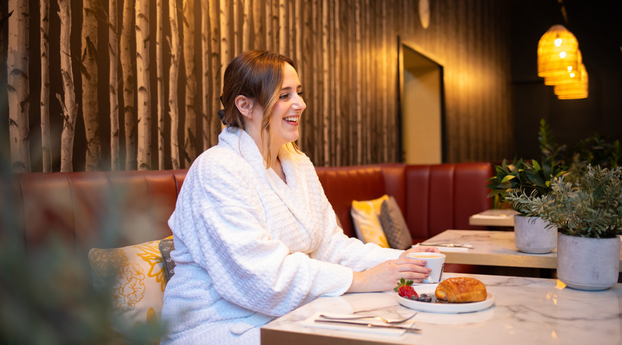 Woman enjoying a pastry in the Vitalé Café Bar.